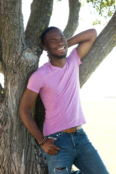 Feliz joven relajándose en el árbol — Foto de Stock