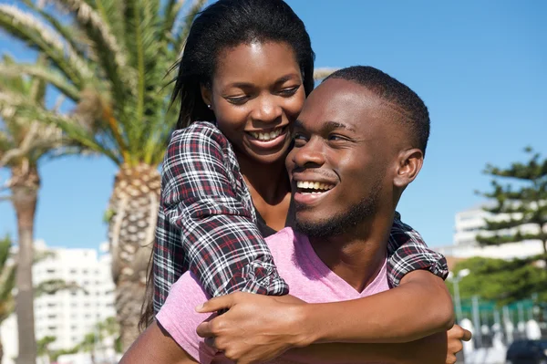 Gelukkige jonge paar lachen samen buitenshuis — Stockfoto