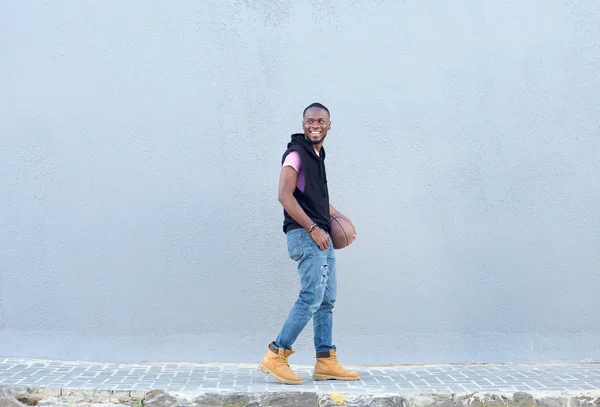 Junger Mann läuft mit Basketball auf Gehweg — Stockfoto