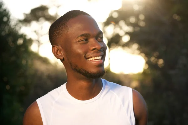 Веселый молодой африканский американец улыбается на улице — стоковое фото