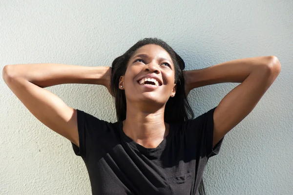 Mujer afroamericana sonriente con las manos detrás de la cabeza — Foto de Stock