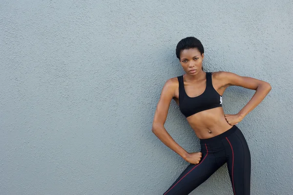 Kendine güvenen genç spor kadın kalça elleri ile poz