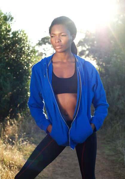 Привлекательная спортивная женщина в синей толстовке, стоящая на природе — стоковое фото