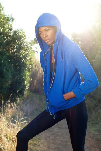 Женская фитнес-модель позирует в синей футболке на улице — стоковое фото