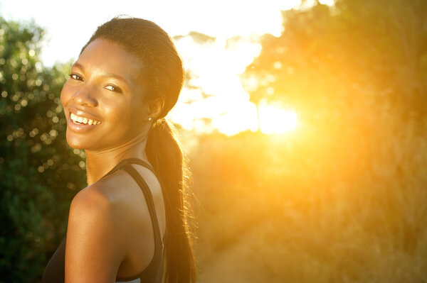 Attractive young sports woman smiling outdoors