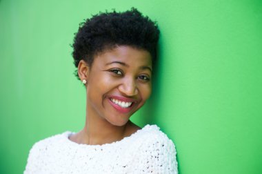 Yeşil arka plan üzerinde gülümseyen sevimli genç kadın