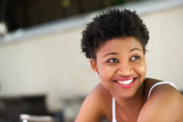 Nette junge Frau lächelt draußen — Stockfoto