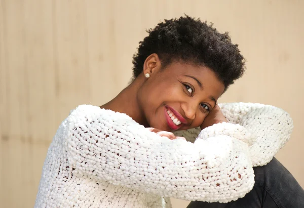 Smiling african american woman sitting outdoors — Stock Photo, Image