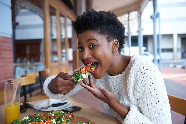 Young african american woman eating pizza — Stock Photo, Image