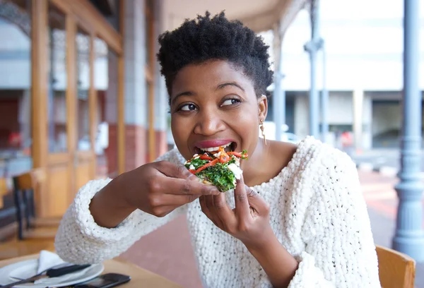 Gelukkig jonge vrouw pizza eten in restaurant — Stockfoto