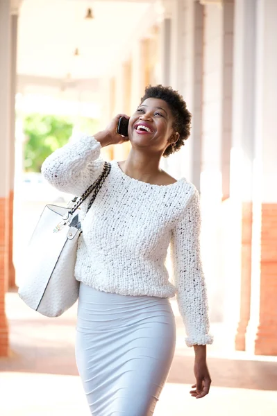 Mujer afroamericana caminando y hablando con teléfono celular —  Fotos de Stock