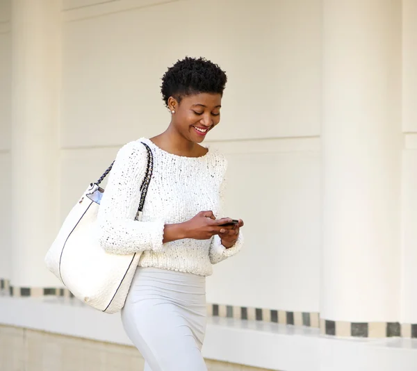 Mujer sonriente que envía mensajes de texto en el teléfono móvil —  Fotos de Stock