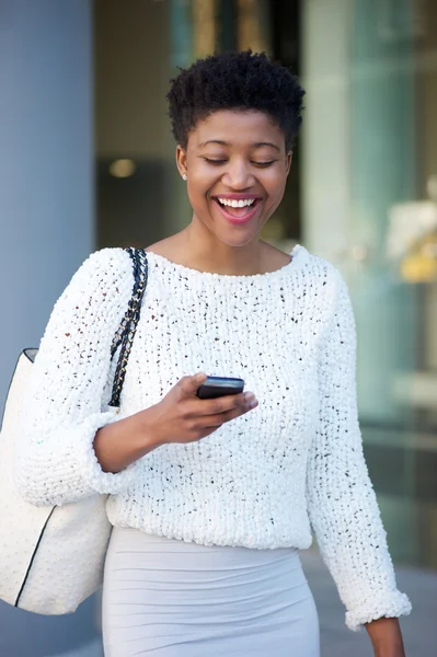 Jeune femme noire riant et lisant un message texte — Photo