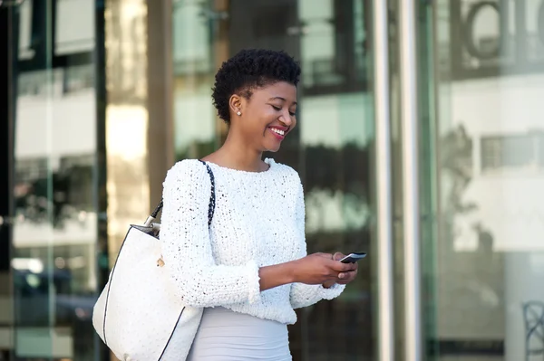 Cheerful young woman walking with cellphone — Stock Photo, Image