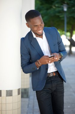 Genç işadamı gönderen kısa mesaj cellphone tarafından gülümseyen