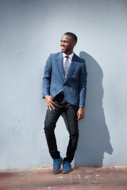 Gri arka planı ayakta gülümseyen iş adamı