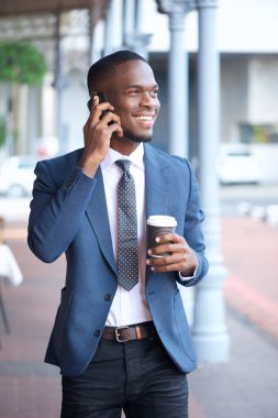 Yürüyüş ve cep telefonu üzerinde konuşurken Modern iş adamı