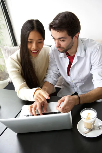 Due amici seduti a tavola con computer portatile — Foto Stock