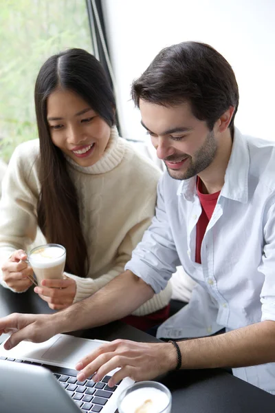 Amici che si rilassano con una tazza di caffè e lavorano sul computer portatile — Foto Stock