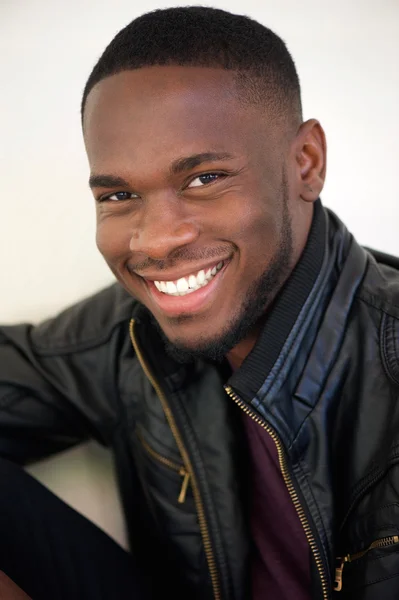 Привлекательный молодой человек, улыбающийся в черной кожаной куртке — стоковое фото