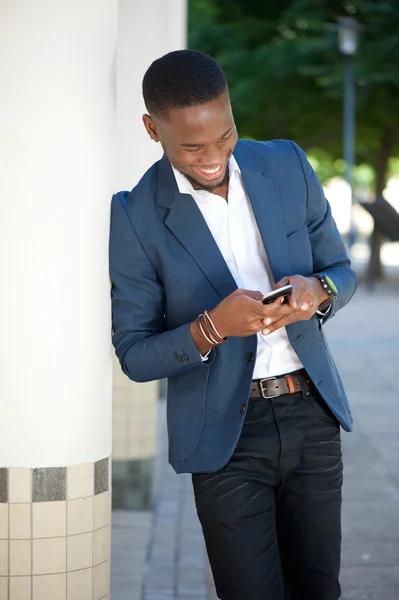 문자 메시지를 전송 하는 아프리카계 미국인 남자를 웃 고 — 스톡 사진