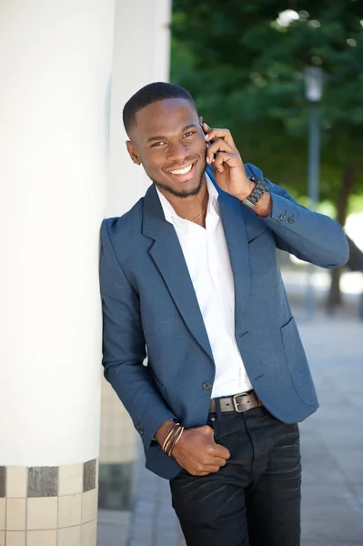 Un jeune homme d'affaires souriant appelle par téléphone portable — Photo