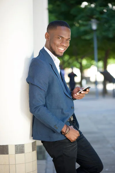 Cool businessman sending text message by mobile phone — Stock Photo, Image