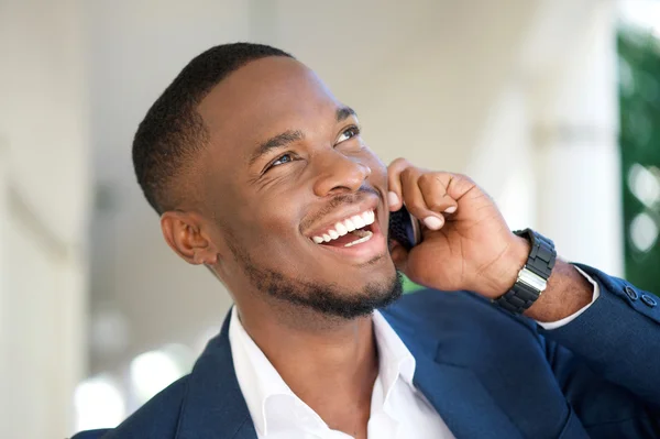 Smiling young businessman calling by mobile phone — Stock Photo, Image