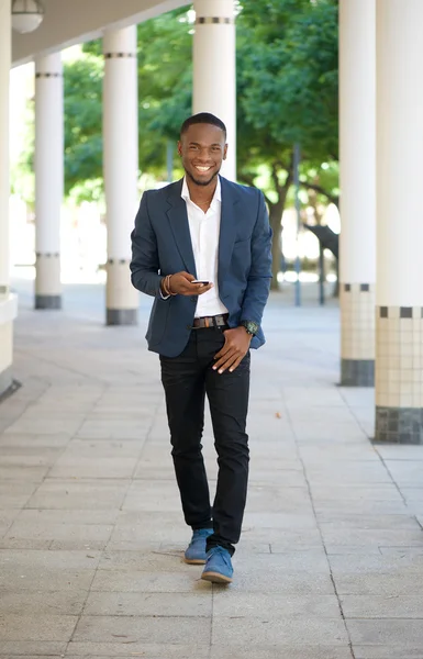 Cool black guy walking with mobile phone — Stock Photo, Image