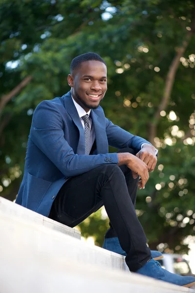 Happy businessman sitting on steps outdoors — Stock Photo, Image