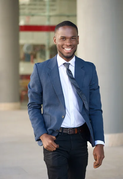 Un hombre de negocios sonriente caminando por la ciudad — Foto de Stock
