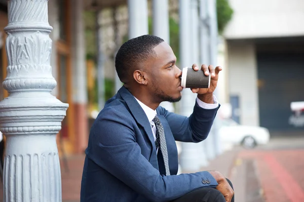 Young businessman relaxing and drinking coffee in the city — Stock Photo, Image
