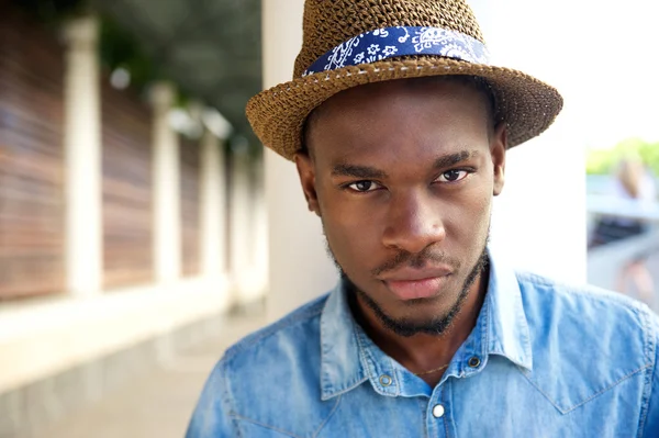 Coole junge afrikanisch-amerikanische Mann posiert im Freien mit Hut — Stockfoto