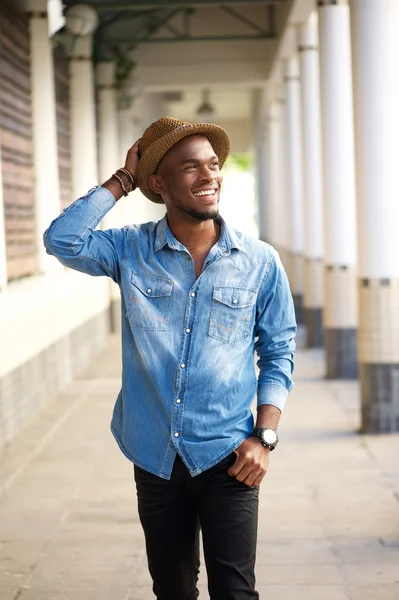 Счастливый молодой африканский американец ходит в шляпе — стоковое фото