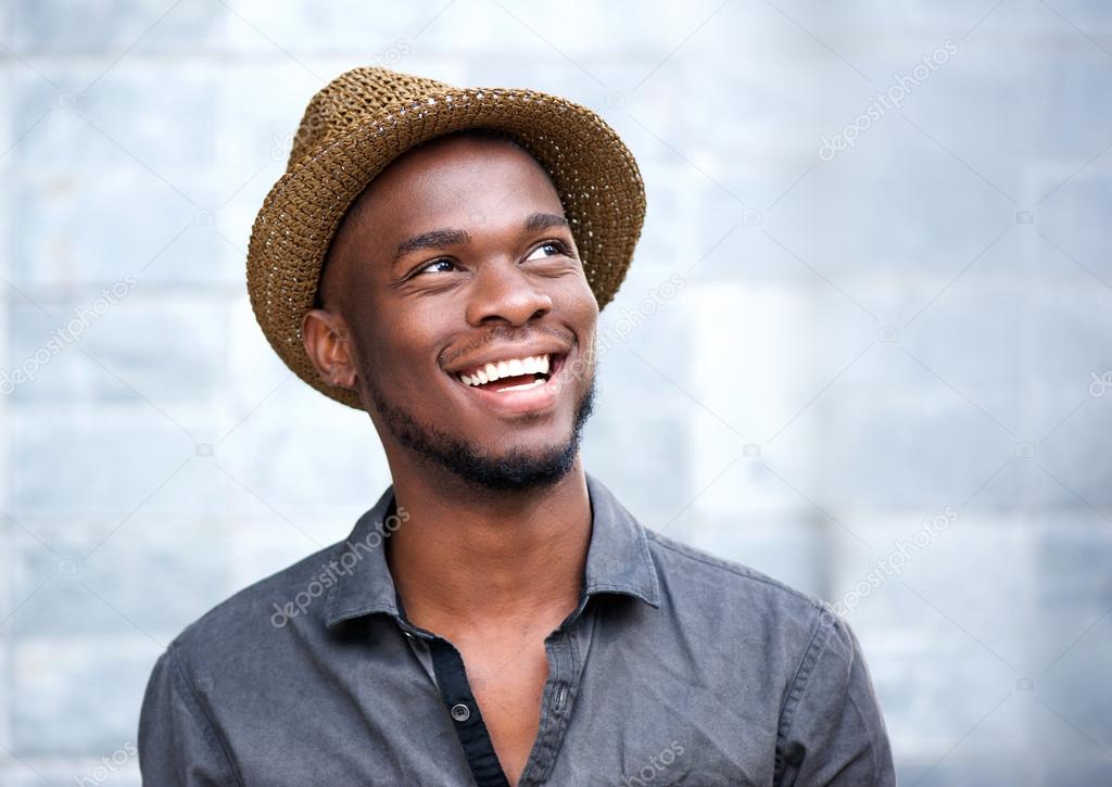 Close up portrait of a happy young african american man laughing 