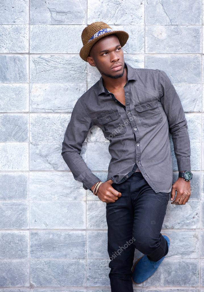 Handsome young african american man leaning against wall