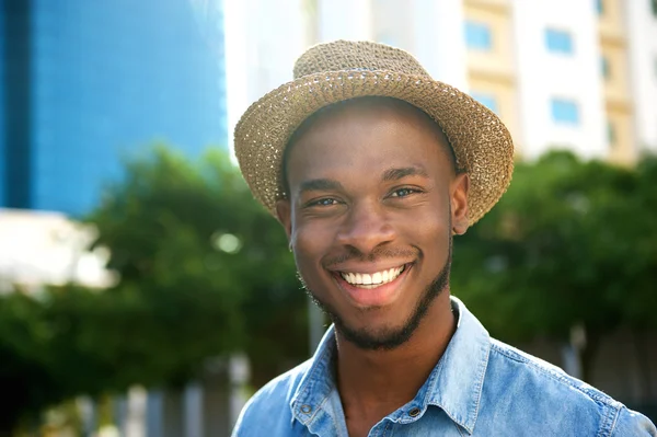 Młody człowiek african american uśmiechający się z kapeluszem — Zdjęcie stockowe