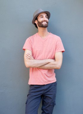 Silah ile gülümseyen yakışıklı adam gri arka plan üzerinde çarpı işareti