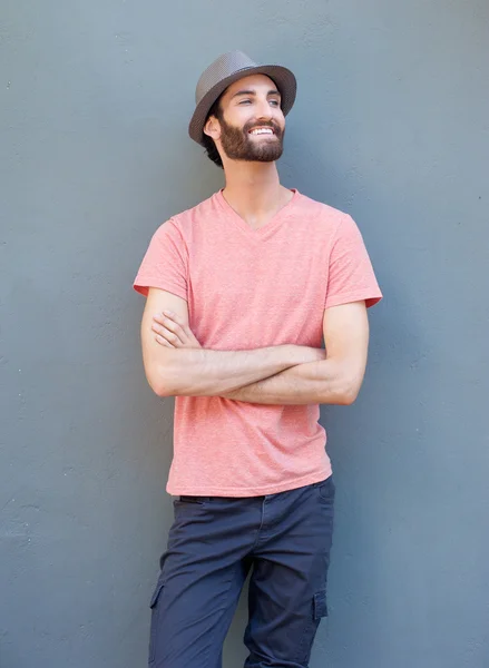 Schöner Mann lächelt mit verschränkten Armen auf grauem Hintergrund — Stockfoto