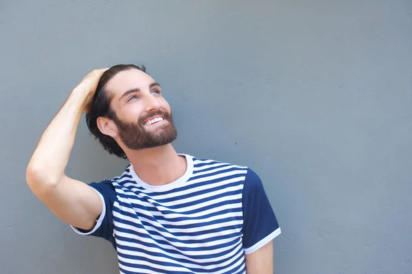 Feliz joven sonriendo con la mano en el pelo — Foto de Stock