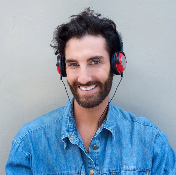Szczęśliwy młody człowiek z brodą słuchanie muzyki w słuchawkach — Zdjęcie stockowe