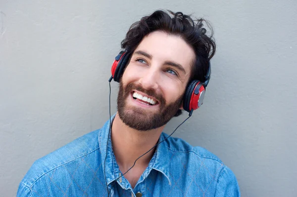Щасливий чоловік обличчя посміхається з навушниками — стокове фото