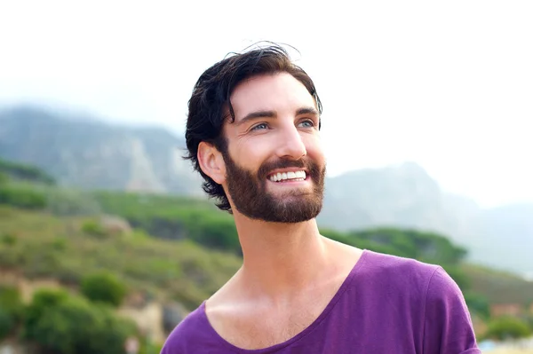 Glücklich lächelnder Mann mit Bart, der draußen in der Natur steht — Stockfoto
