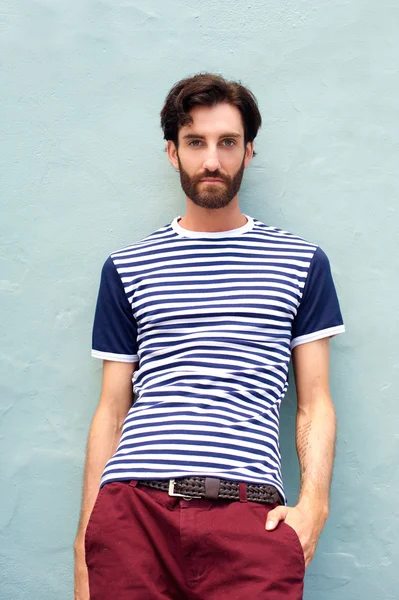 Cool male model in striped shirt leaning against wall — Stock Photo, Image