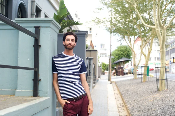 Casual knappe jonge man permanent buiten in striped shirt — Stockfoto