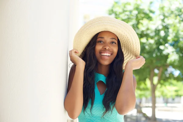 Joyeux jeune femme riant et tenant chapeau de soleil — Photo