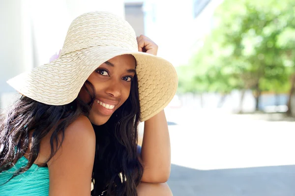 Joyeux jeune femme noire souriant avec chapeau de soleil à l'extérieur — Photo