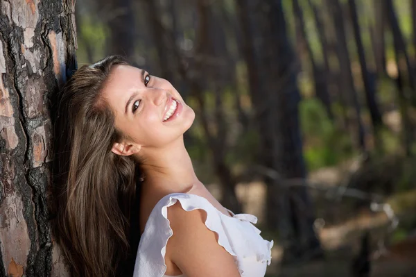 Mooie jonge vrouw die lacht in het bos — Stockfoto