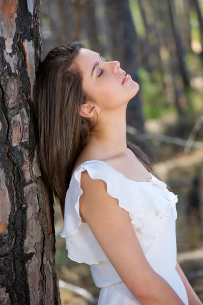 Elegante junge Frau mit geschlossenen Augen im Wald — Stockfoto