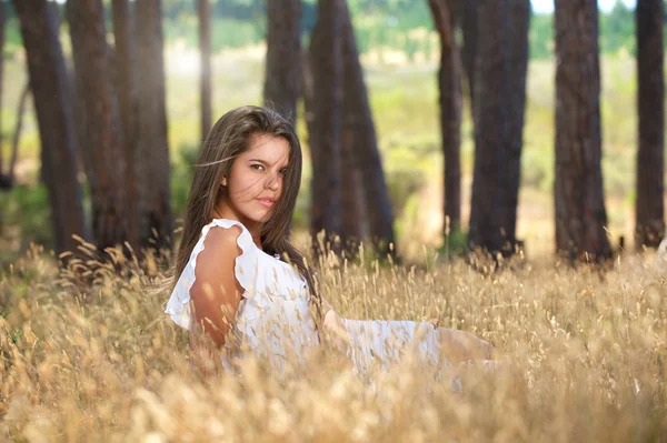 Sinnliche junge Frau sitzt auf einem Feld in der Natur — Stockfoto